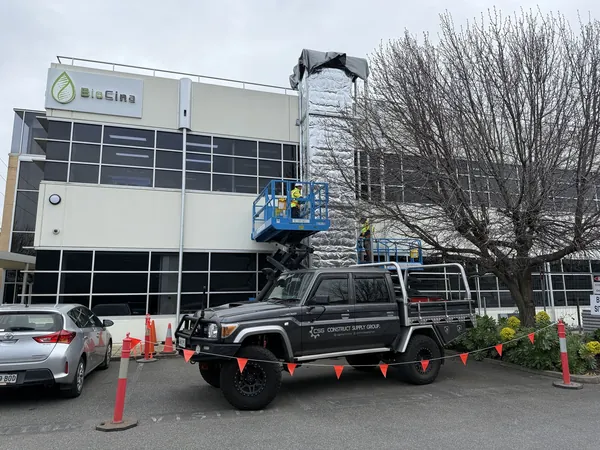 External duct riser being installed on a commercial building from an elevated work platform