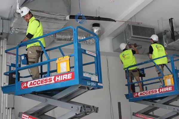 CSG Air technicians on scissor lifts installing ceiling ductwork