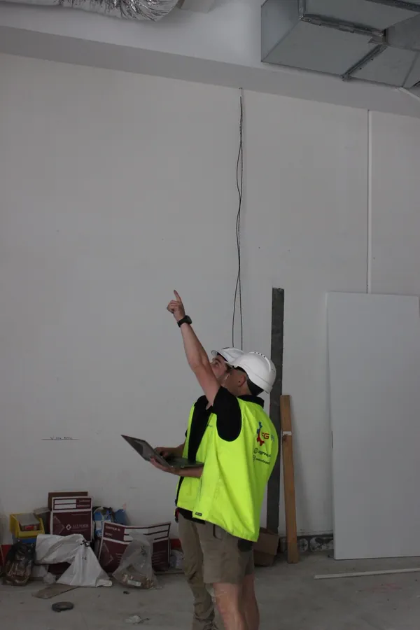 CSG Air technician in hi-vis inspecting ceiling services on a construction site